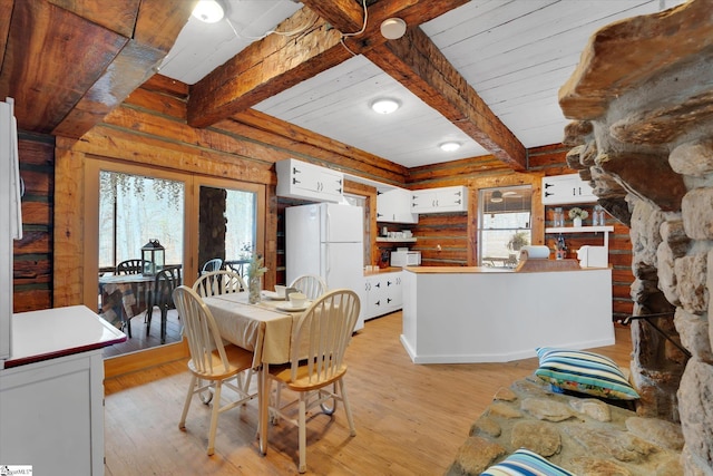 dining area featuring beam ceiling, a wealth of natural light, and light wood-type flooring