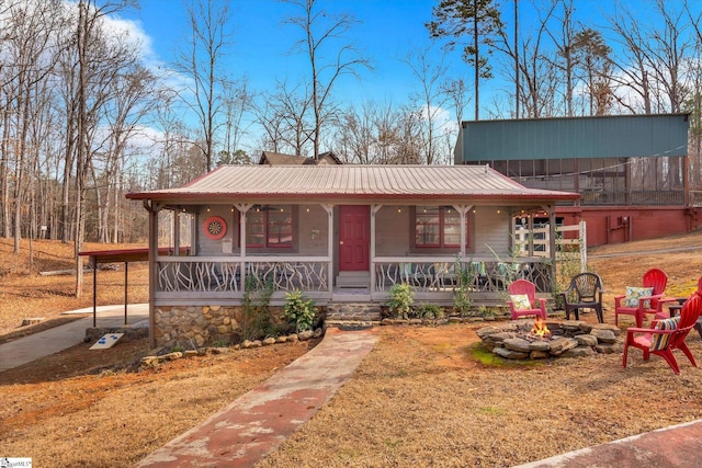 view of front of property with a carport, covered porch, and an outdoor fire pit