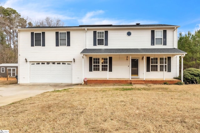 view of property featuring a garage, a front yard, and covered porch