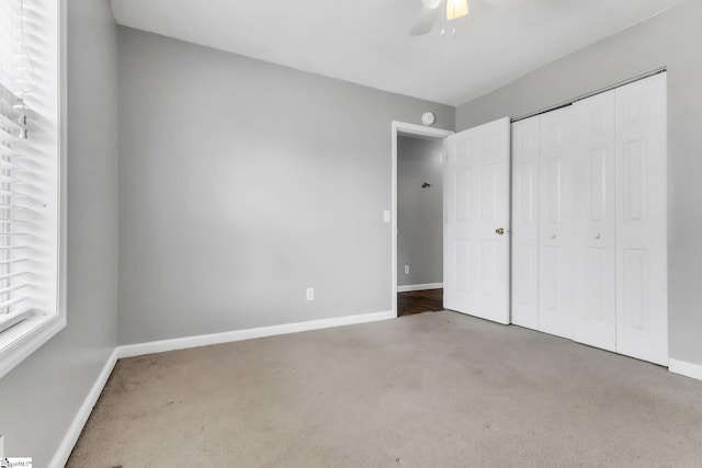 unfurnished bedroom featuring carpet, ceiling fan, and a closet