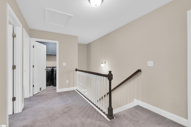 corridor with independent washer and dryer and carpet flooring