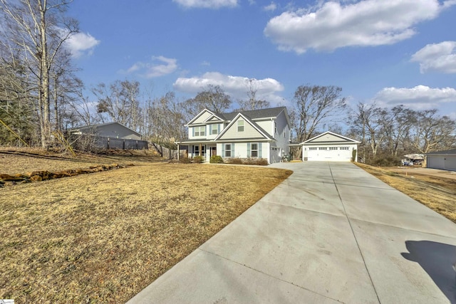 view of front of property with a garage, an outdoor structure, a front yard, and covered porch