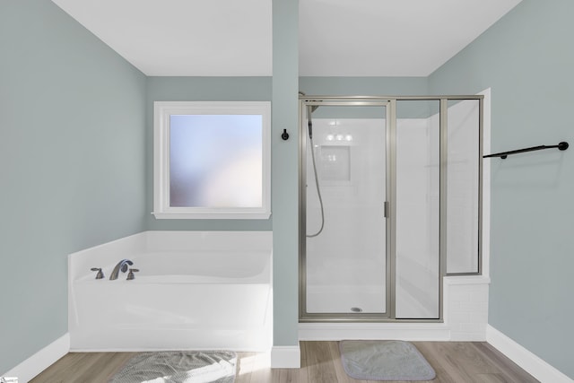 bathroom with hardwood / wood-style flooring and separate shower and tub