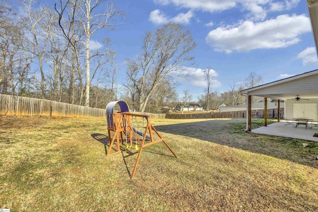 view of yard with ceiling fan, a playground, and a patio