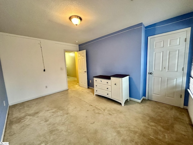 unfurnished bedroom with light colored carpet and a textured ceiling