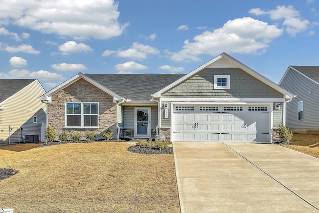 view of front of home with cooling unit, a garage, and a front lawn