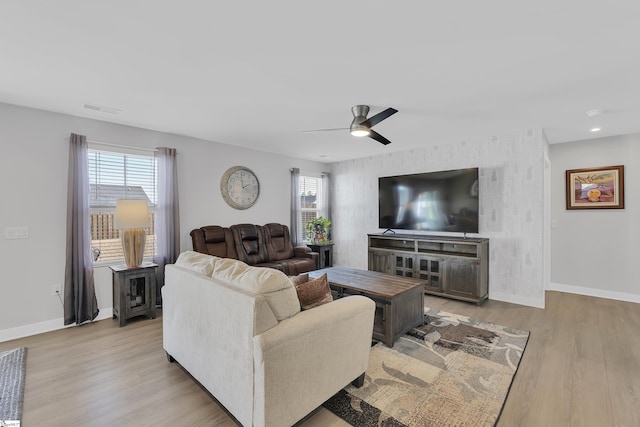 living room featuring plenty of natural light, ceiling fan, and light wood-type flooring