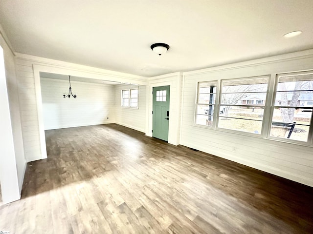 unfurnished living room featuring dark wood-style floors and a notable chandelier