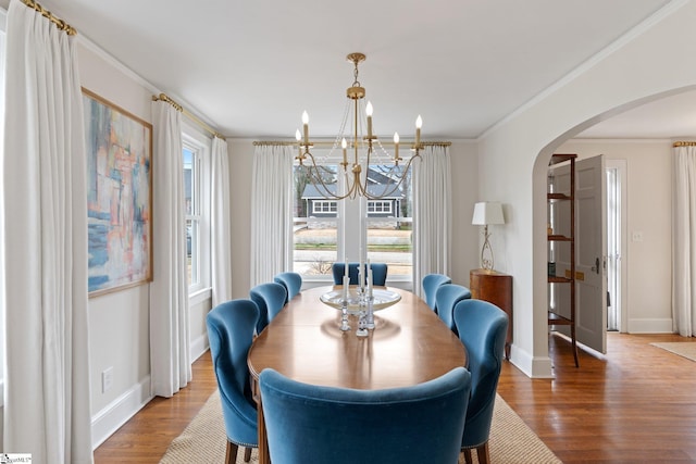 dining room with crown molding, hardwood / wood-style floors, and a chandelier