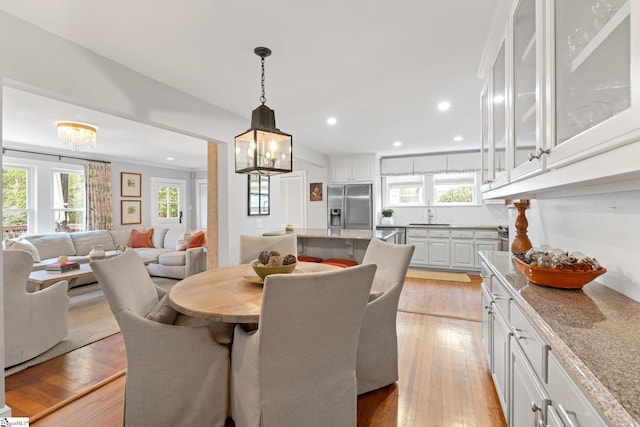 dining space with sink and light hardwood / wood-style floors