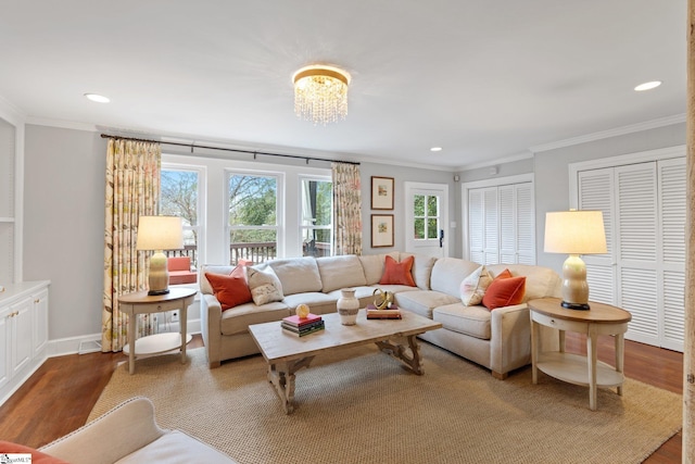 living room with an inviting chandelier, hardwood / wood-style flooring, and ornamental molding