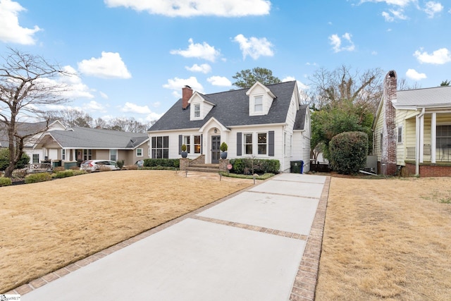 cape cod-style house with a front lawn