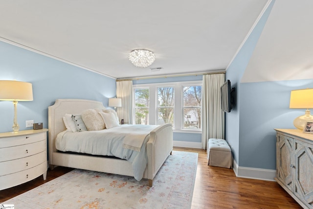 bedroom with ornamental molding and hardwood / wood-style floors