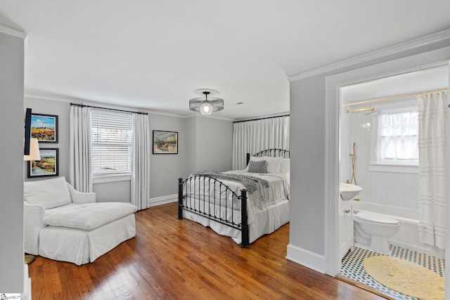 bedroom featuring ornamental molding, wood-type flooring, and ensuite bathroom