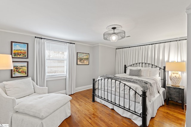 bedroom with hardwood / wood-style floors and crown molding