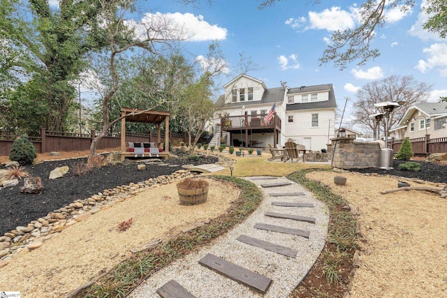 rear view of property featuring a wooden deck, a fire pit, and a patio