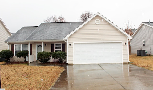 ranch-style home featuring a garage, a shingled roof, central AC, and concrete driveway