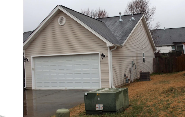 view of home's exterior with central AC unit and a garage