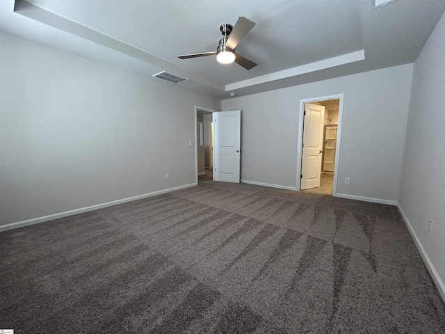 unfurnished bedroom with ceiling fan and dark carpet