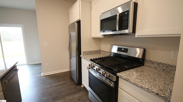 kitchen with light stone counters, stainless steel appliances, dark hardwood / wood-style floors, and white cabinets