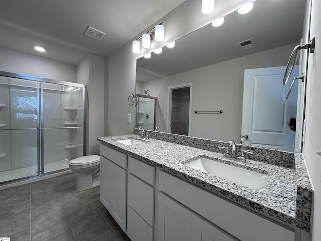 bathroom with an enclosed shower, vanity, tile patterned flooring, and toilet