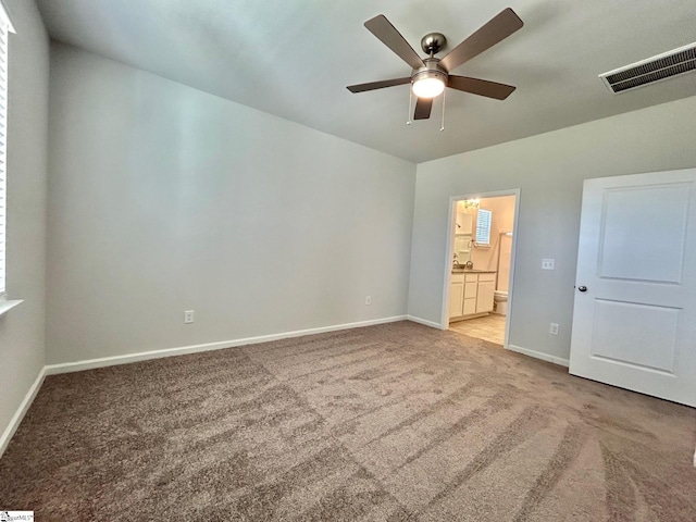 unfurnished bedroom featuring connected bathroom, light carpet, and ceiling fan