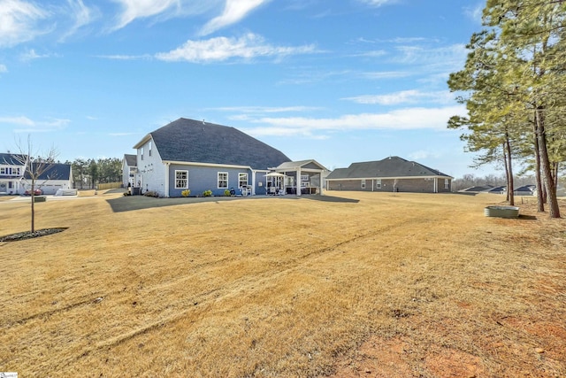 rear view of property featuring a lawn