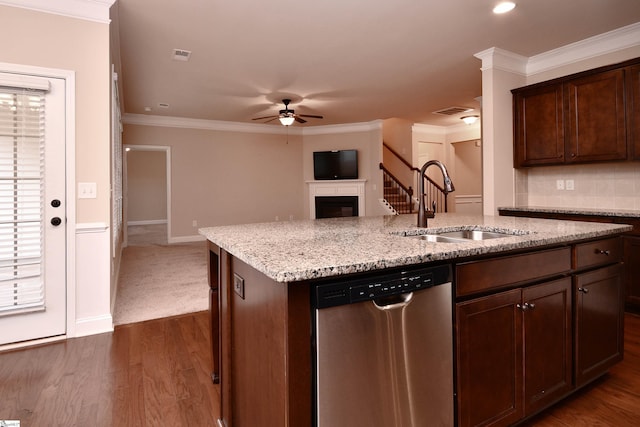 kitchen with sink, dark brown cabinets, stainless steel dishwasher, and a center island with sink