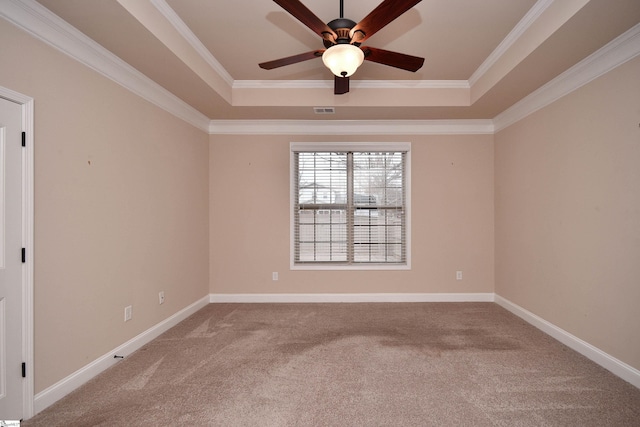 spare room featuring ornamental molding, carpet flooring, and a tray ceiling