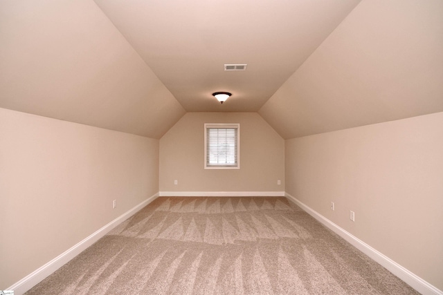 bonus room with vaulted ceiling and carpet floors