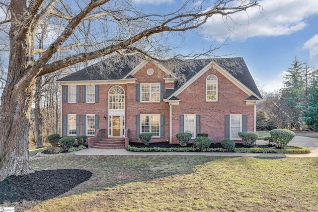 colonial-style house featuring a front yard