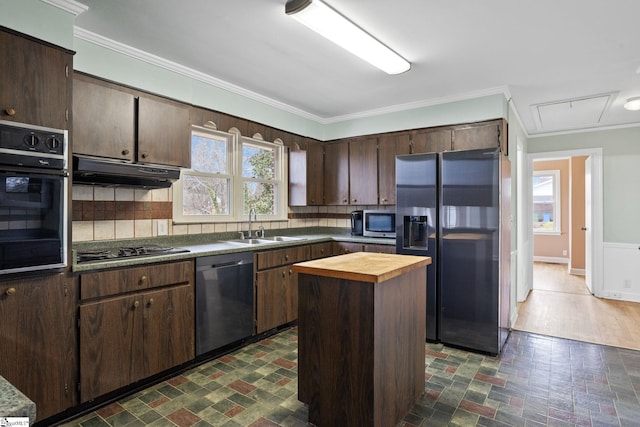 kitchen with sink, butcher block countertops, a center island, ornamental molding, and black appliances