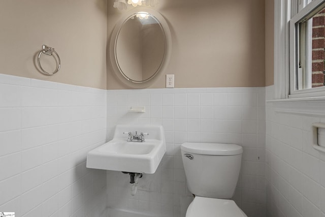 bathroom featuring tile walls, sink, and toilet
