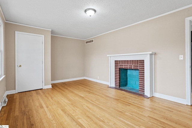 unfurnished living room featuring a brick fireplace, light hardwood / wood-style flooring, ornamental molding, and a textured ceiling