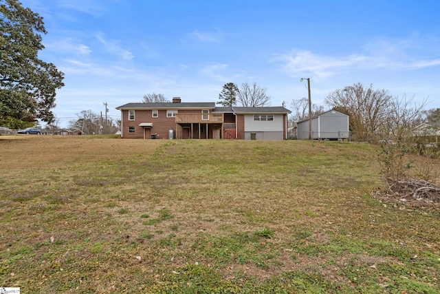 rear view of property featuring a wooden deck and a lawn