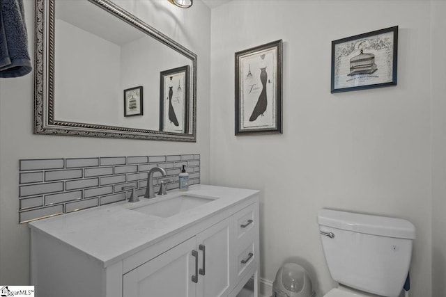 bathroom with vanity, toilet, and backsplash