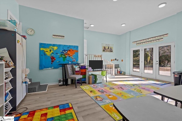 rec room featuring light wood-type flooring and french doors