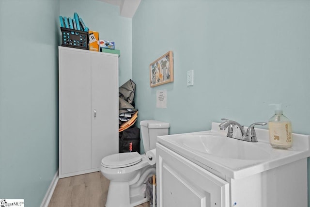 bathroom with vanity, wood-type flooring, and toilet