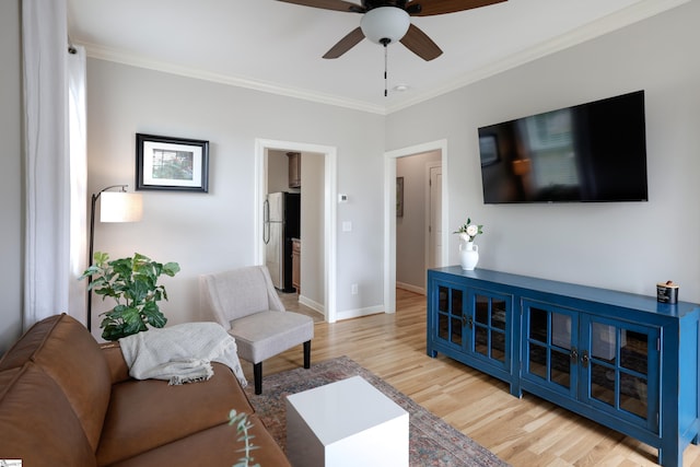 living room with crown molding, light hardwood / wood-style floors, and ceiling fan