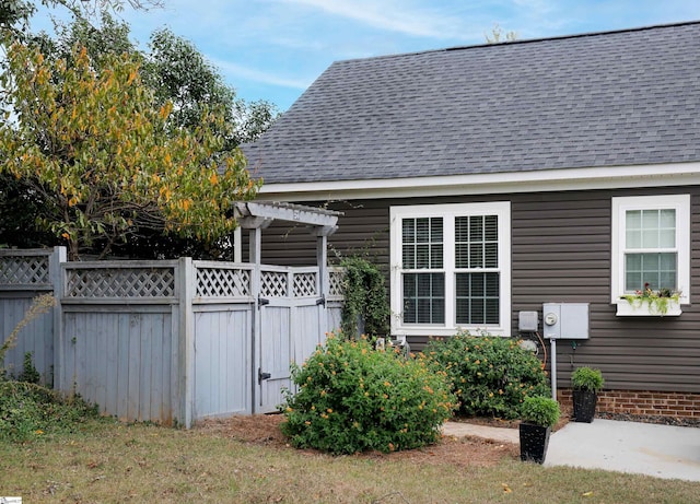 view of side of property with a yard and a pergola