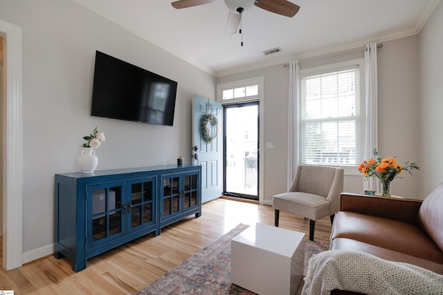 living room featuring crown molding, ceiling fan, and light hardwood / wood-style floors