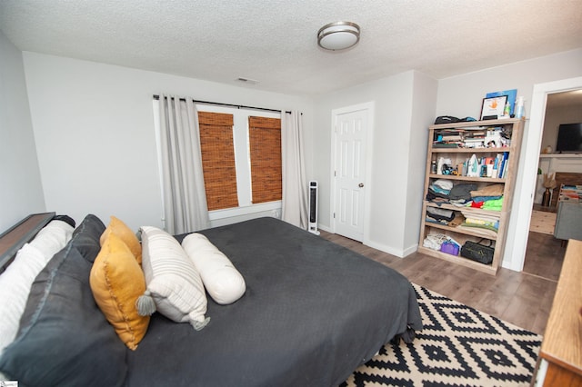 bedroom with dark wood-type flooring and a textured ceiling