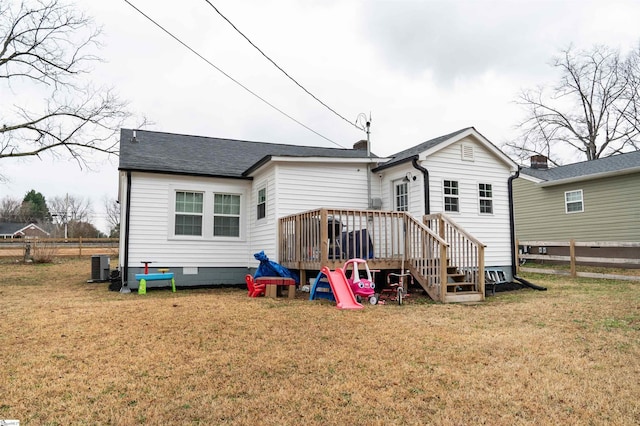 rear view of property with a wooden deck and a lawn