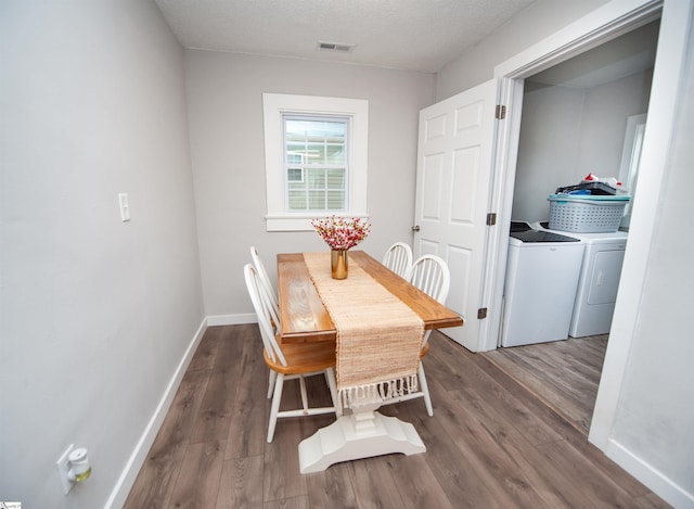 dining space featuring separate washer and dryer, hardwood / wood-style floors, and a textured ceiling