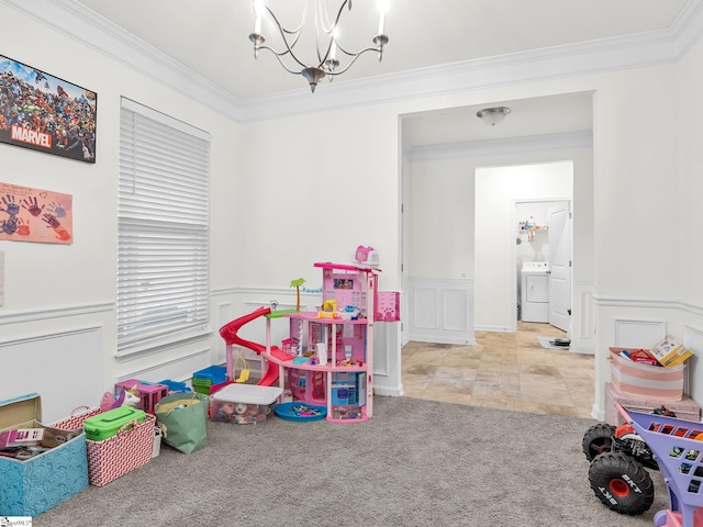 rec room with light carpet, washer / clothes dryer, ornamental molding, and a chandelier