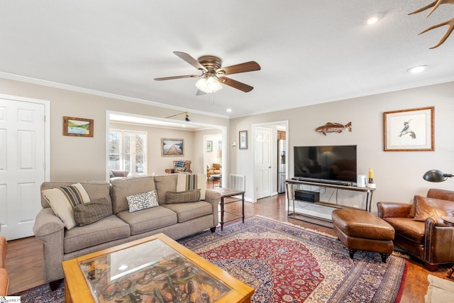 living room featuring crown molding, ceiling fan, and hardwood / wood-style floors