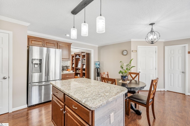 kitchen featuring stainless steel refrigerator with ice dispenser, a center island, pendant lighting, and dark hardwood / wood-style floors