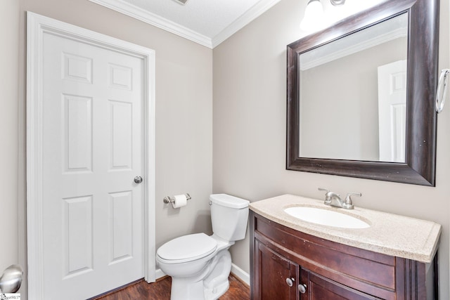 bathroom with vanity, ornamental molding, hardwood / wood-style floors, and toilet