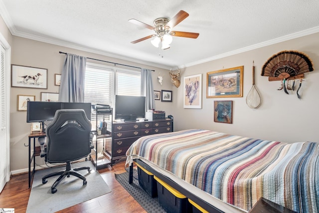 bedroom featuring dark wood-type flooring, ceiling fan, crown molding, and a textured ceiling