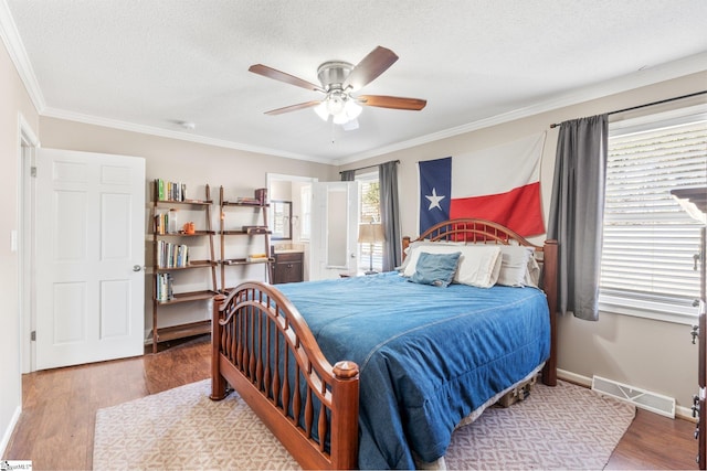 bedroom with hardwood / wood-style floors, ornamental molding, and a textured ceiling